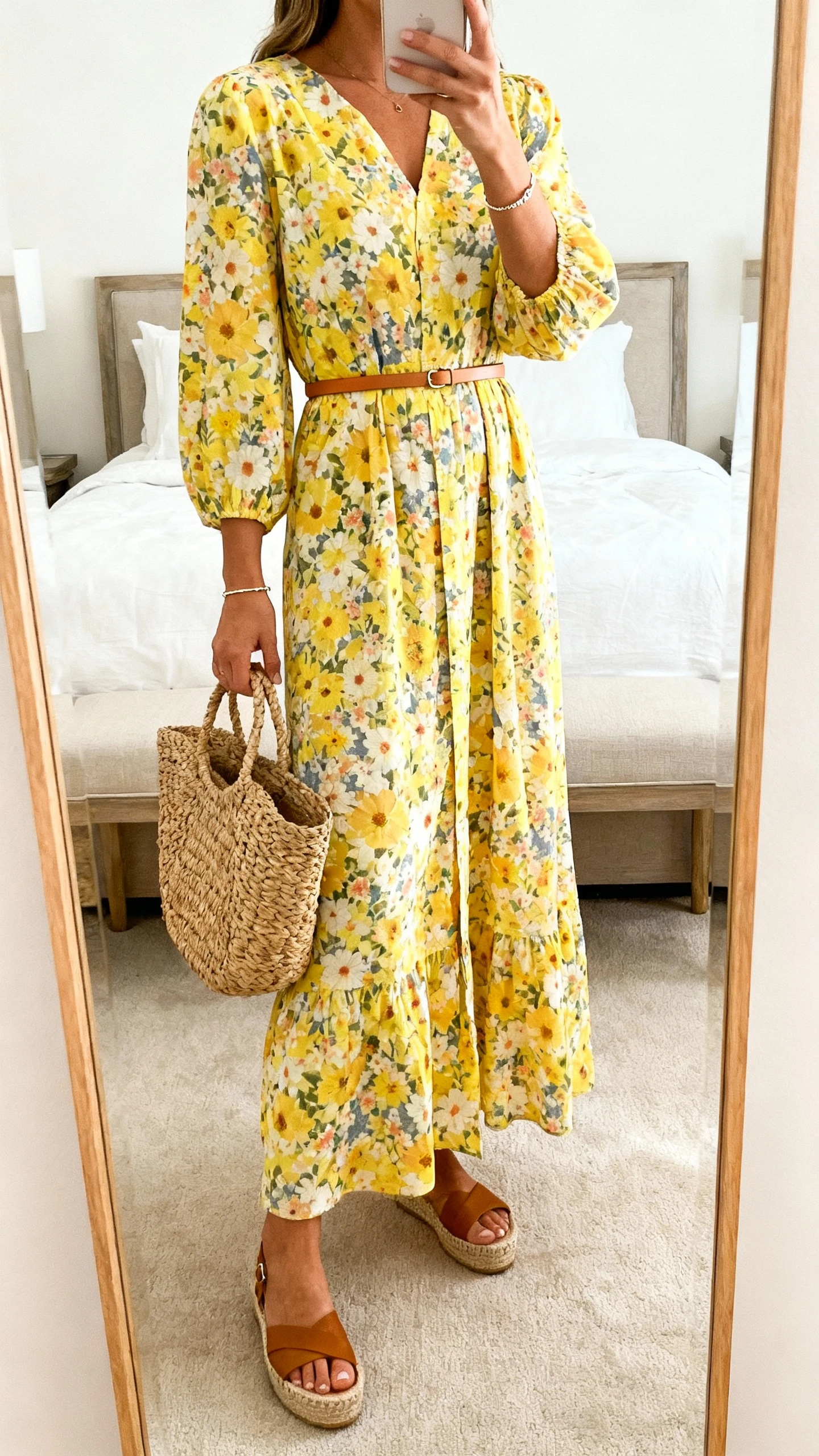iPhone mirror selfie of a woman wearing a sunny floral maxi dress cinched with a slim belt and espadrille wedges, straw tote and dainty bracelet, face not visible, cropped at shoulders, bedroom mirror, bright natural light, iPhone photo quality.