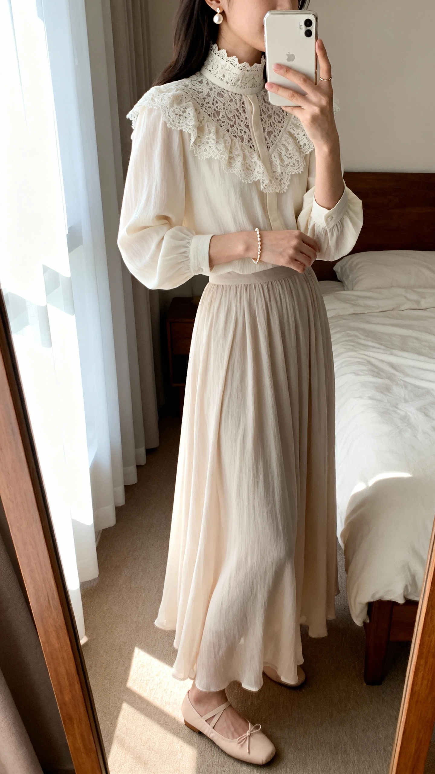 iPhone side-angle mirror selfie of a woman wearing a lace-trim high-neck blouse paired with a flowing maxi skirt, pearl earrings, delicate bracelet, and ballet flats, face not visible, bedroom mirror with gentle window light, iPhone photo quality.