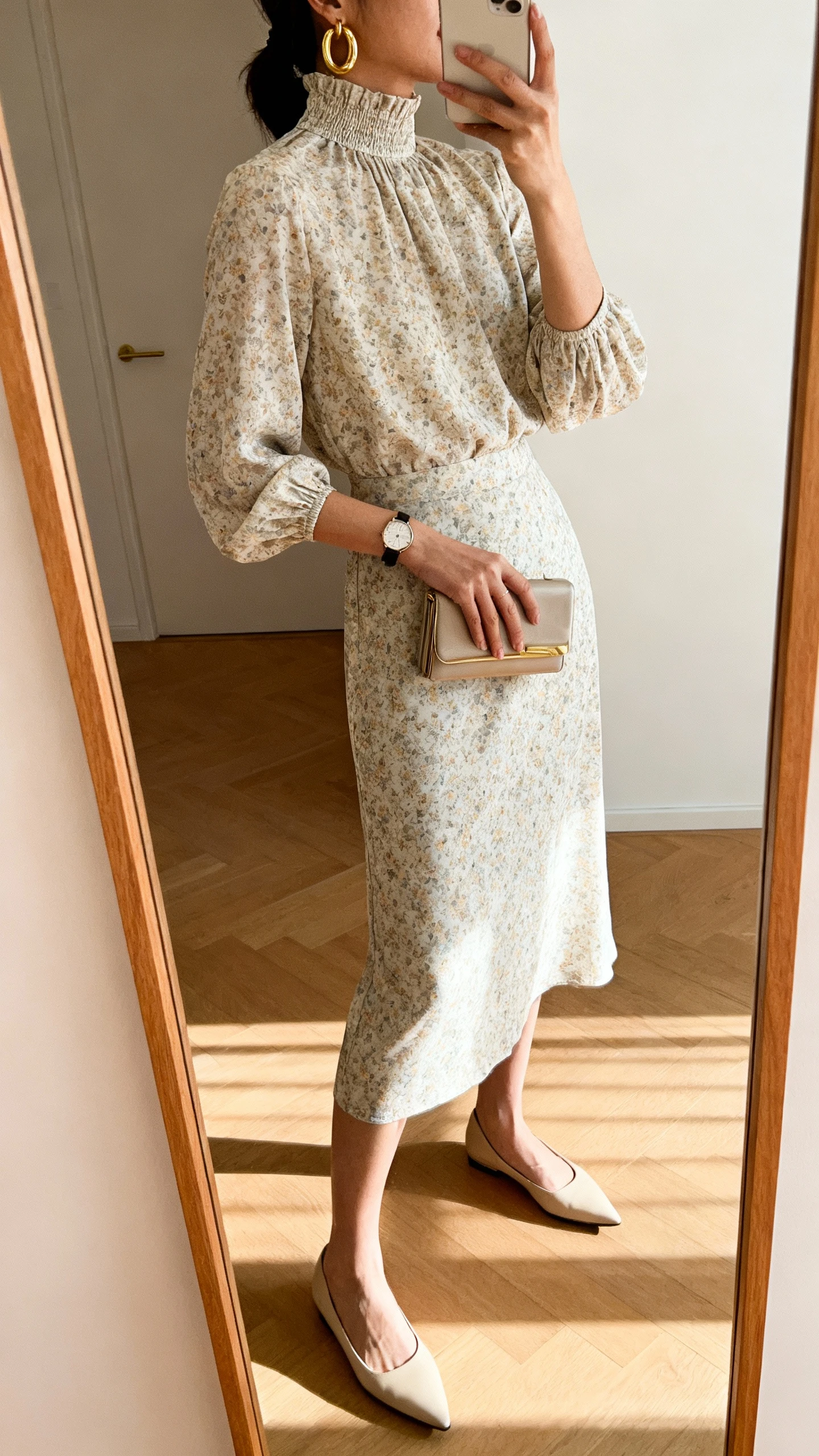 iPhone side view mirror selfie of a woman wearing an elegant high-neck midi dress with subtle floral print, polished accessories (gold hoop earrings, slim watch), pointed-toe flats, and a compact clutch, face not visible, full-length mirror, warm indoor lighting, iPhone photo quality.